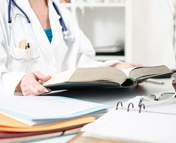 Medical professional with books and paperwork