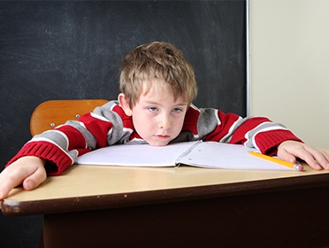 Young boy falling asleep in class