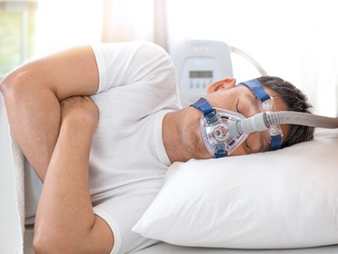 Man sleeping with CPAP mask