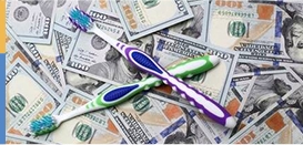 Toothbrushes resting on pile of money