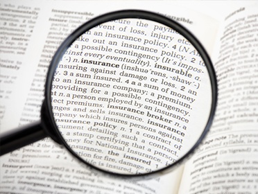 Magnifying glass looking at word insurance