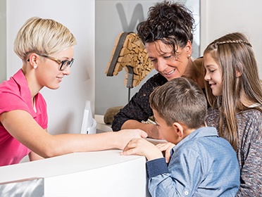 Mother and two kids at dental reception desk