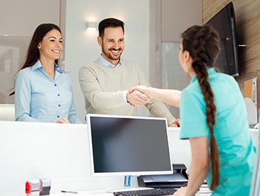 Two people checking in at reception desk